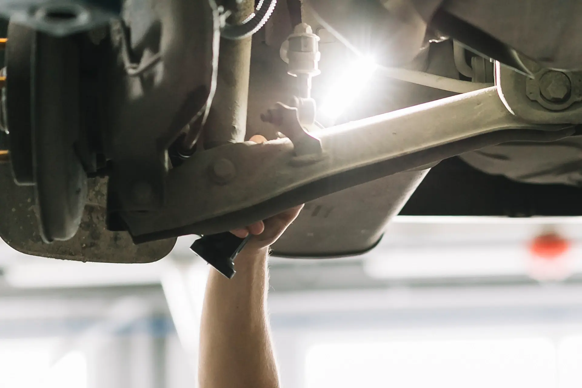 Reparatur eines Querlenkers am Fahrwerk eines Autos in der Werkstatt Dörfelt in Zwickau